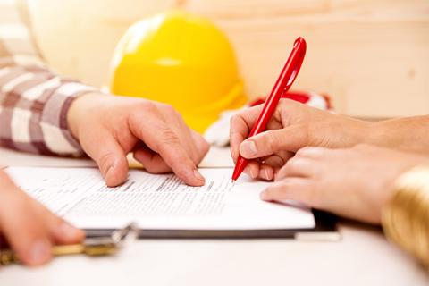 two people on a construction site review and sign a contract symbolizing legal issues in construction management